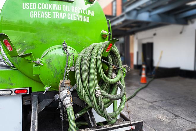 a grease trap being pumped by a sanitation technician in Goodyear